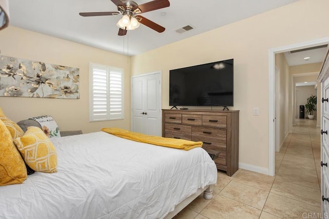 tiled bedroom featuring ceiling fan and a closet