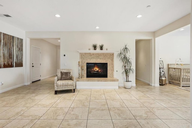 unfurnished room with a tile fireplace and light tile patterned floors