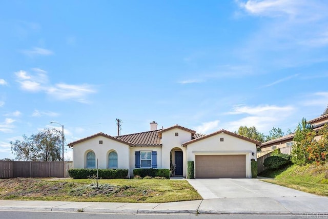 mediterranean / spanish house featuring a garage and a front yard