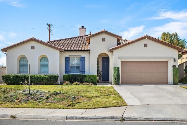 mediterranean / spanish-style house featuring a garage and a front lawn