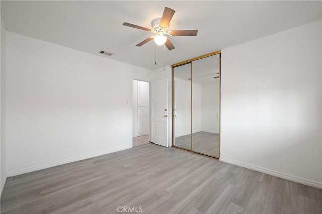 unfurnished bedroom with a closet, ceiling fan, and light wood-type flooring