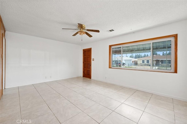 spare room featuring light tile patterned floors, a textured ceiling, and ceiling fan