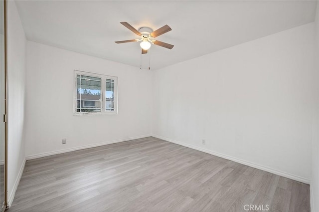 spare room with ceiling fan and light wood-type flooring