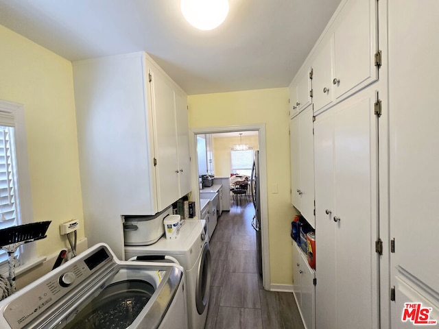 clothes washing area featuring cabinets and washing machine and clothes dryer