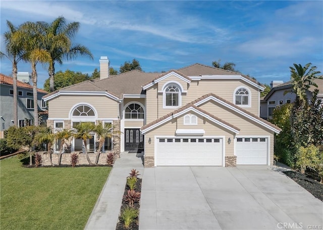 view of property featuring a garage and a front lawn