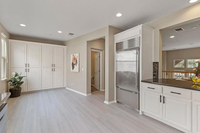 kitchen with light hardwood / wood-style flooring, white cabinets, and stainless steel built in refrigerator