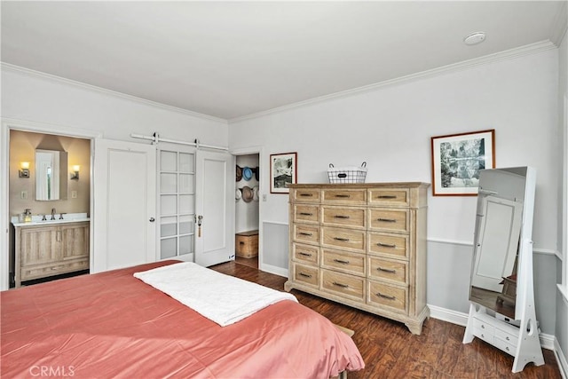 bedroom featuring dark wood-type flooring, crown molding, a sink, and a barn door