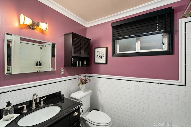 bathroom with toilet, a wainscoted wall, ornamental molding, vanity, and tile walls