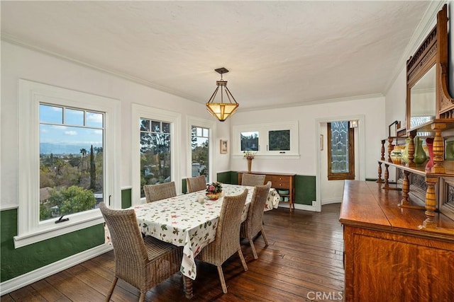 dining room featuring ornamental molding, dark wood-type flooring, and baseboards