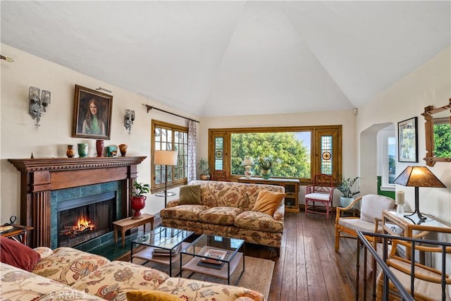 living room with high vaulted ceiling, a fireplace with flush hearth, and dark wood finished floors