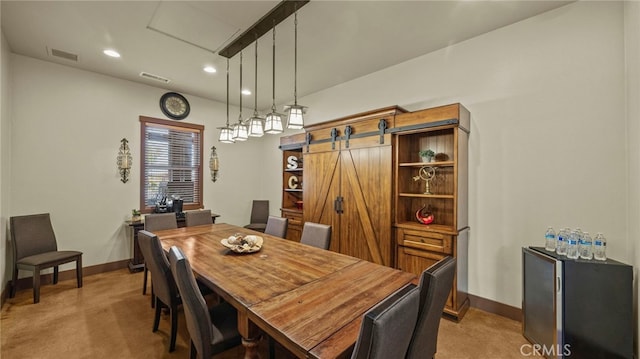 carpeted dining room featuring a barn door