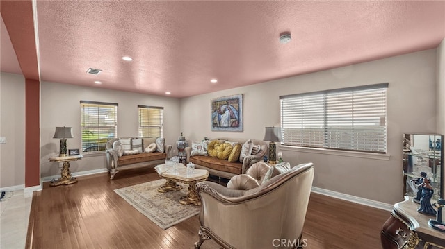 living room with dark hardwood / wood-style floors and a textured ceiling