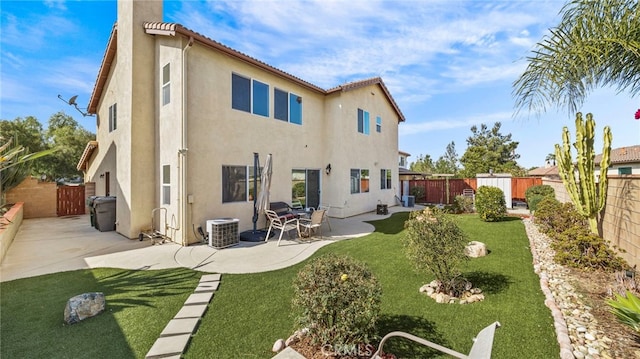 rear view of property featuring cooling unit, a patio area, and a lawn