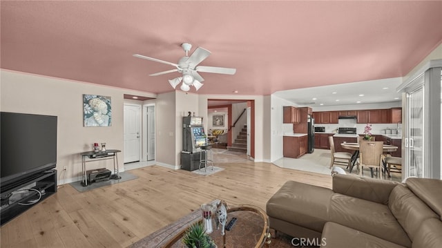 living room with ceiling fan and light hardwood / wood-style flooring