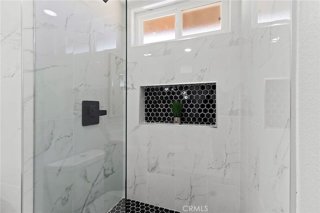 bathroom featuring toilet and tiled shower