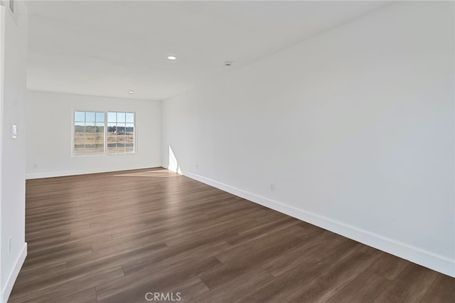 spare room with dark wood-type flooring