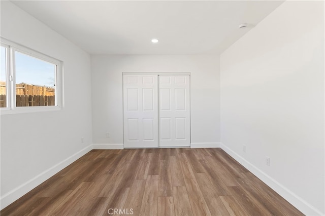 unfurnished bedroom with a closet and dark hardwood / wood-style floors