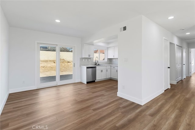 kitchen featuring tasteful backsplash, dishwasher, sink, white cabinets, and dark wood-type flooring