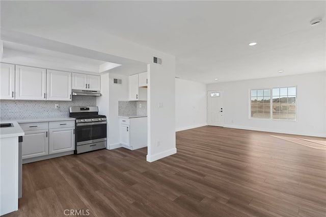 kitchen with backsplash, stainless steel range with gas stovetop, white cabinets, and dark hardwood / wood-style flooring