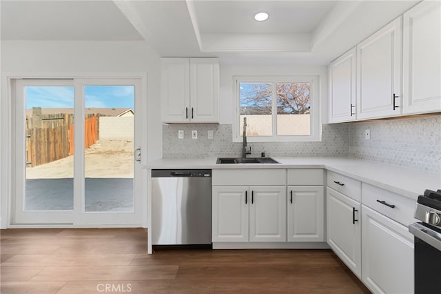 kitchen with appliances with stainless steel finishes, a raised ceiling, sink, and white cabinets