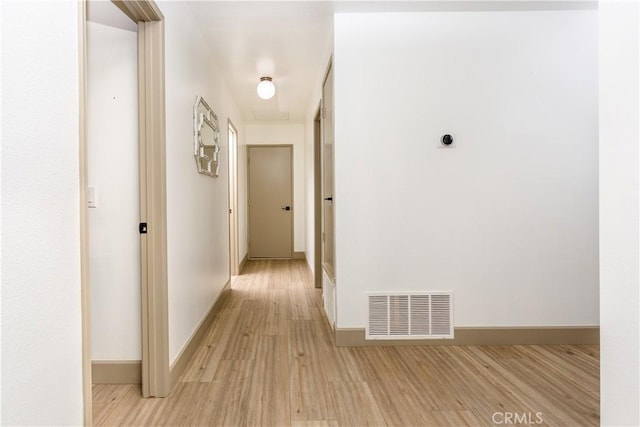 hallway with light hardwood / wood-style floors