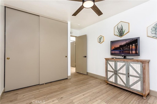 unfurnished bedroom featuring ceiling fan, a closet, and light hardwood / wood-style flooring