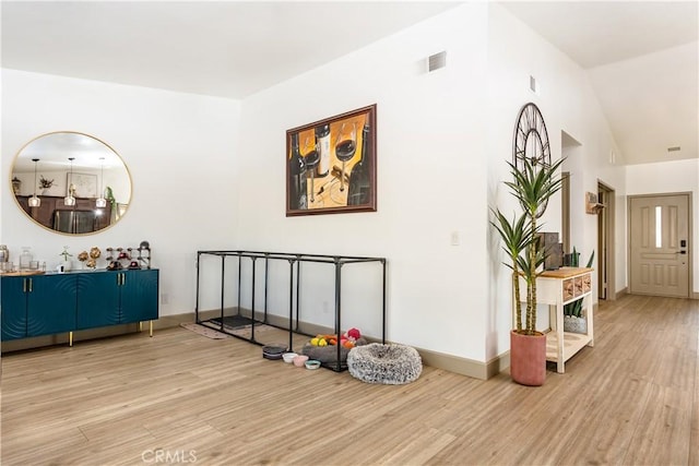 hallway featuring lofted ceiling and light hardwood / wood-style flooring