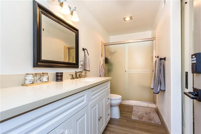 bathroom featuring an enclosed shower, hardwood / wood-style floors, vanity, and toilet