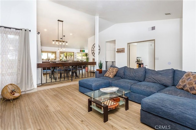 living room featuring lofted ceiling and light hardwood / wood-style flooring