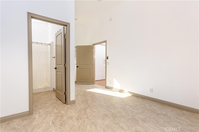 unfurnished room featuring a towering ceiling