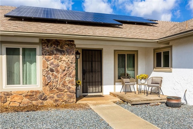 property entrance with a wooden deck and solar panels