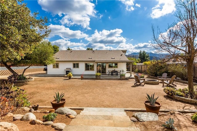 rear view of house featuring a mountain view, a patio area, and an outdoor fire pit