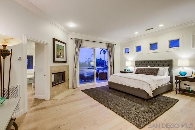 bedroom featuring crown molding, access to exterior, and light hardwood / wood-style flooring