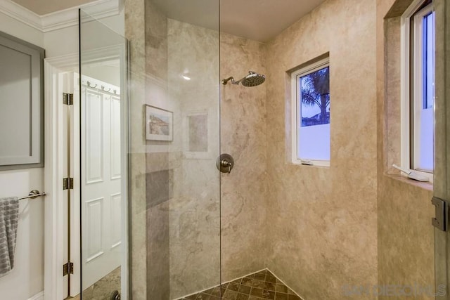 bathroom with ornamental molding and tiled shower