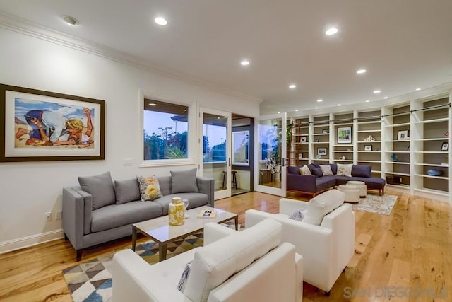 living room with built in features, ornamental molding, and light wood-type flooring