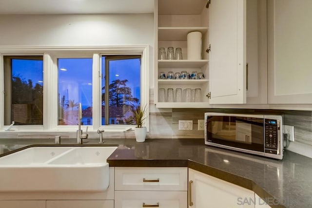 kitchen featuring white cabinetry, sink, and tasteful backsplash