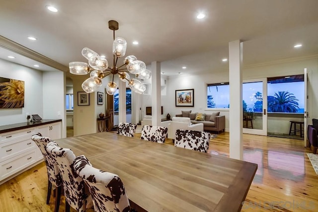 dining room with light hardwood / wood-style flooring, ornamental molding, and french doors