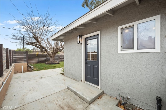 view of exterior entry featuring a patio