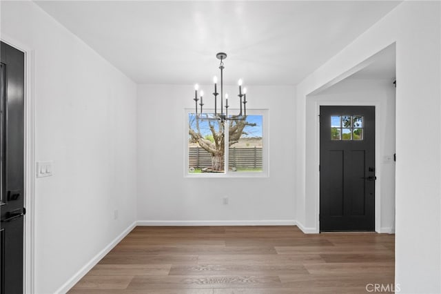 entrance foyer featuring light hardwood / wood-style floors and a chandelier