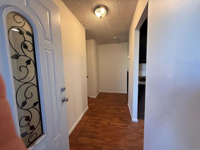 hallway featuring dark hardwood / wood-style floors and a textured ceiling