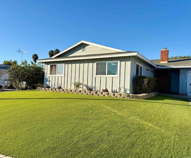 view of side of home with a yard and board and batten siding