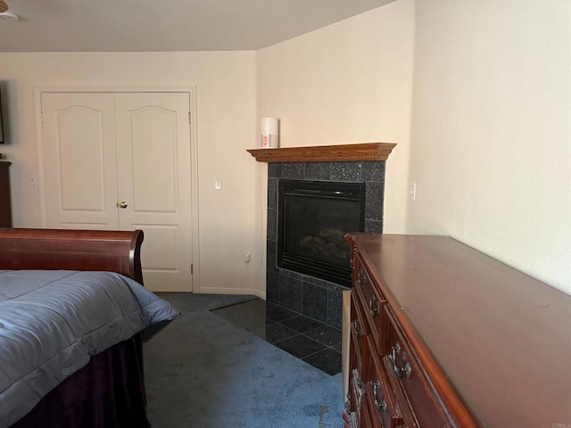 bedroom featuring a tile fireplace and dark colored carpet