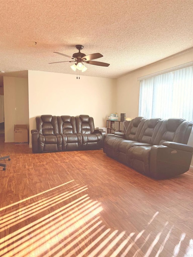 living area featuring a textured ceiling, ceiling fan, and wood finished floors