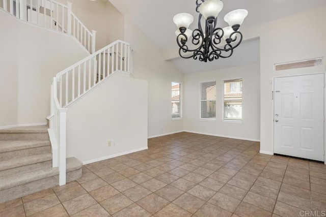 tiled foyer entrance with a chandelier and high vaulted ceiling