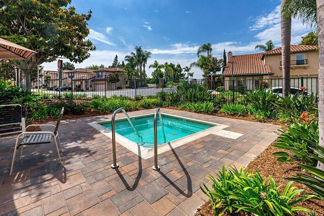 view of pool with a patio and a community hot tub