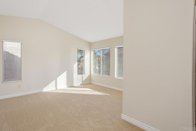 carpeted empty room featuring lofted ceiling