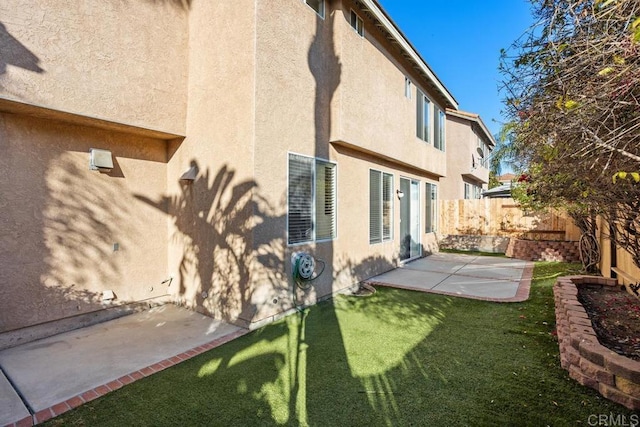 back of house featuring a lawn and a patio area