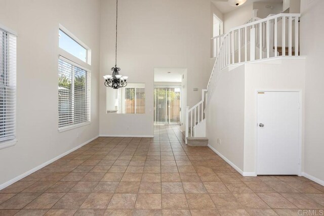 foyer featuring light tile patterned flooring, a chandelier, and a wealth of natural light