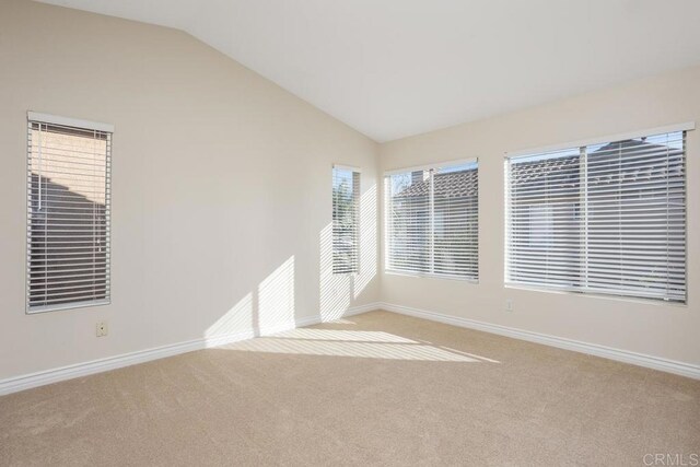 empty room featuring lofted ceiling and light carpet