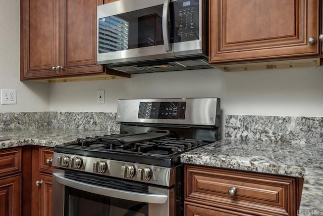 kitchen featuring stainless steel appliances and light stone countertops